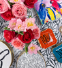 multiple sized plates with bunny decals, bouquets of flowers, and a box with painted parrots on a black and white rabbit tablecloth